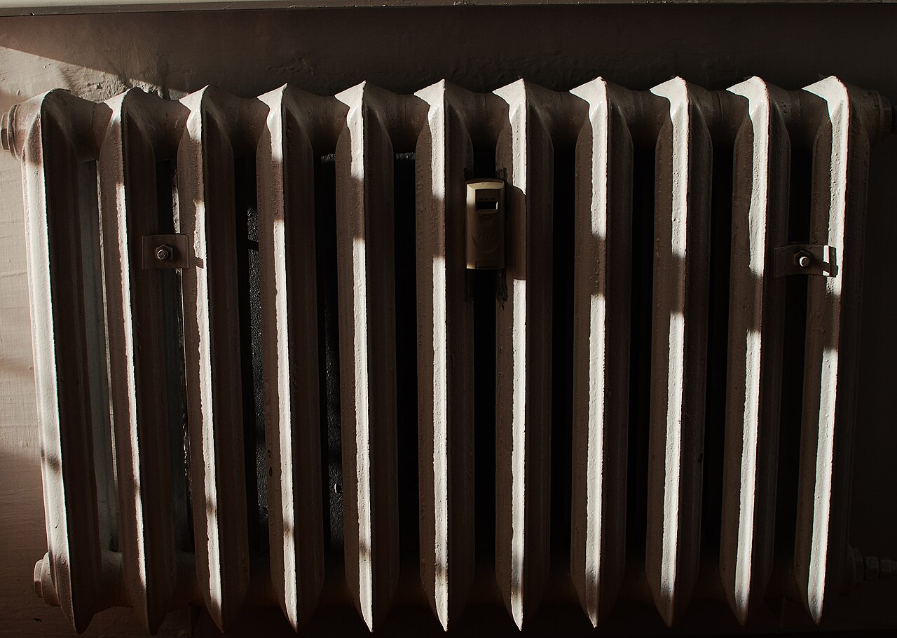 An older cast-iron radiator beneath a window